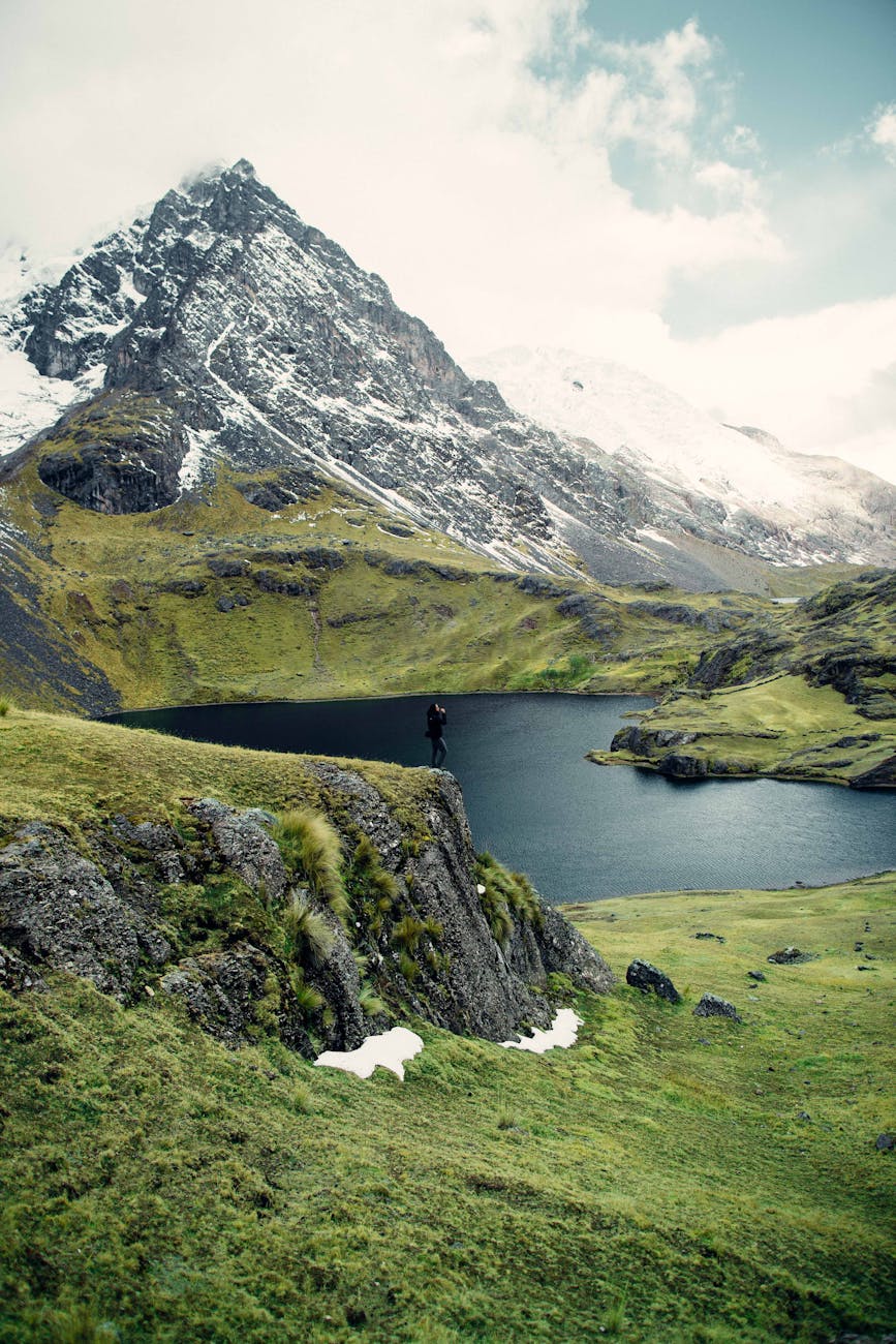person looking out off an edge of a mountain